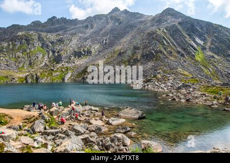 Wanderer und Schwimmer am Gold Cord Lake im Sommer in der Independence Mines Gegend des Hatcher Pass in der Nähe von Palmer, Süd-Zentral Alaska Stockfoto