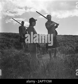 Jagd auf Zackenbarsche auf Skye-Jagd. Frau mit einer Flinte und zwei Männern in einem Kilt Date: Undated Location: Scotland, Skye Keywords: Guns, Hunters, Women Stockfoto