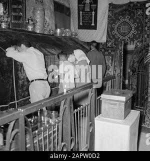 Israel 1964-1965: Jerusalem (Jerusalem), Kirchen und Klöster Jerusalem. Grab von König David: Besucher beten an der Grabrede: Das Grab befindet sich im Erdgeschoss und dient heute als Synagoge und Betraum. Der Grabstein ist mit einem Samttuch bedeckt und darauf Tora-Kronen aus Synagogenkreisen jüdischer Gemeinden, der Grabstein selbst hat Aufschriften und Verzierungen aus der Kreuzfahrerzeit. Sowohl Die Letzte Abendmahlshalle als auch das Grab Davids befinden sich im selben Baudatum: 1964 Ort: Israel, Jerusalem, Berg Zion Schlüsselwörter: Pilgerreisen, Besucher, beten, Gräber, Synagogenbauten Stockfoto