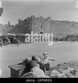 Israel 1948-1949 Jerusalem. Blick auf das Herodes Gate mit Bussen, Autos und Öffentlichkeit mit einem Brothändler im Vordergrund Datum: 1948 Ort: Israel, Jerusalem Schlüsselwörter: Architektur, Autos, Busse, Brot, Stadtstatuen, Stadtmauern, Stadttore, Straßenhändler, Verkehrsmittel Personenname: Herodes the Great (König) Stockfoto