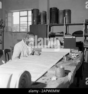 Israel 1964-1965: Jerusalem (Jerusalem), Thorarrolls Jerusalem. Autoren beschreiben Schriftrollen an einem Arbeitstisch Anmerkung: Die Tora (das Mosaische Gesetz) ist auf einer Rolle geschrieben, die aus Pergament aus der Haut eines koscheren Tieres besteht. Die verschiedenen Teile von Pergament sind mit einer Sehne aneinander befestigt, der Text wird handschriftlich geschrieben. Die Tinte wird oft von selbst hergestellt und muss bestimmte Anforderungen erfüllen. Schließlich ist die Rolle an zwei Holzstöcken mit Griffen befestigt und beide Enden werden gegen das mittlere Datum gerollt: 1964 Ort: Israel, Jerusalem Schlüsselwörter: Tora, Schriftrolle, Handschrift, jüdische RE Stockfoto