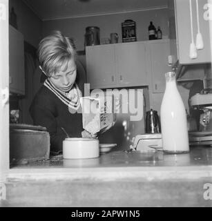 Tag im Leben der Familie Svendsen Boy macht Porridge zum Frühstück bereit Datum: März 1954 Ort: Dänemark Schlüsselwörter: Tägliches Leben, Haushalt, Innenräume, Küchen, Kinder, Mahlzeiten, Milch, Milchflaschen, Heim, Essen, Häuser, Söhne Personname: Svendsen, Stockfoto