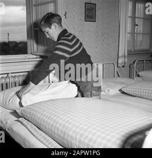 Rheinnavigation, Bericht über das Schiffsinternat in Mannheim Boy macht sein Bett am Datum: 1. April 1955 Standort: Deutschland, Mannheim, Westdeutschland Schlagwörter: Alltag, Internate, Kinder, Schlafzimmer Stockfoto