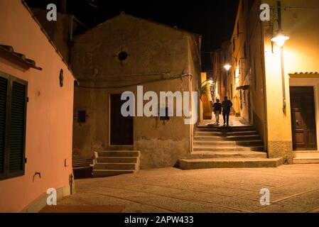 Blick auf die klassische kleine Gasse in der historischen mittelalterlichen italienischen Stadt in der Nacht mit zwei Silhouetten zu Fuß Stockfoto