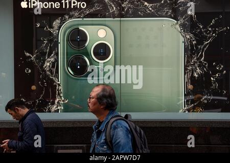 Fußgänger gehen an einer Apple Iphone Werbung in Hongkong vorbei. Stockfoto