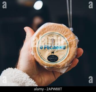 Paris, Frankreich - 27. Dezember 2019: Man Hand mit köstlichen U Pecurino traditionellen korsischen Käse von Pierucci Stockfoto