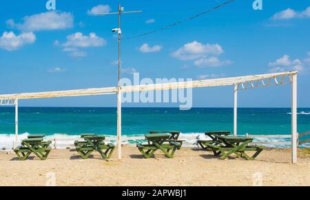 Eine Reihe von Tischen und Bänken vor einer Strandbar an der Kilimli Bay, in der Nähe von Agva, Sile, im Nordwesten der Türkei Stockfoto