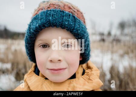 Porträt eines Jungen, der im Winter draußen spielt Stockfoto
