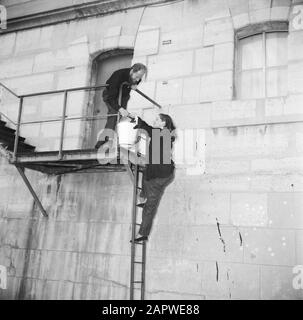 Das Segel-Hausboot Siegfried & Erik am Ufer der seine Mann und Frau beim passieren eines Eimers auf der Treppe entlang der Seinekade in Paris Datum: 1950 Ort: Frankreich, Paris Schlüsselwörter: Paare, Kais, Leitern, Treppen, Frauen Stockfoto