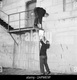 Das Segel-Hausboot Siegfried & Erik am Ufer der seine Mann und Frau beim passieren eines Eimers auf der Treppe entlang der Seinekade in Paris Datum: 1950 Ort: Frankreich, Paris Schlüsselwörter: Paare, Kais, Leitern, Treppen, Frauen Stockfoto