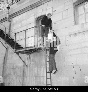 Das Segel-Hausboot Siegfried & Erik am Ufer der seine Mann und Frau beim passieren eines Eimers auf der Treppe entlang der Seinekade in Paris Datum: 1950 Ort: Frankreich, Paris Schlüsselwörter: Paare, Kais, Leitern, Treppen, Frauen Stockfoto