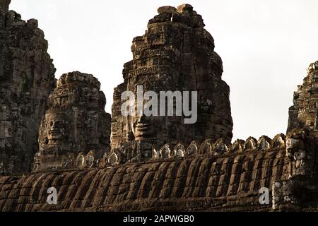 Geschnitzte Gesichter auf Turm am Bayon Tempel während Sonnenuntergang, Angkor, Siem Reap Stockfoto