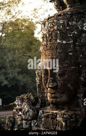 Geschnitztes menschliches Gesicht während des Sonnenuntergangs im Bayon Tempel, Angkor Stockfoto