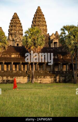 Ein junger buddhistischer Mönch, der bei Sonnenuntergang um Angkor Wat herum spaziert Stockfoto