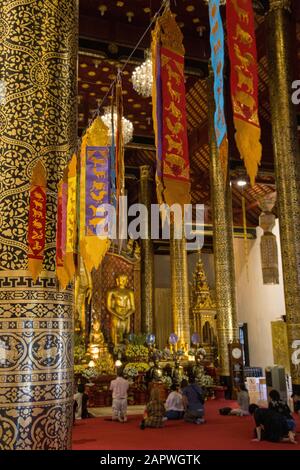 Von oben hängen bunte Seidenbänder im Wat Chedi Luang Stockfoto