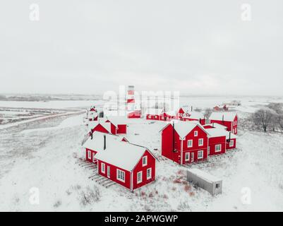 Blick auf die farbenfrohen Holzgebäude. Fischerdorf und Touristenstadt. Rote Holzhäuser des Fischerdorfs in schneebedecktem Schnee im Winter. Stockfoto