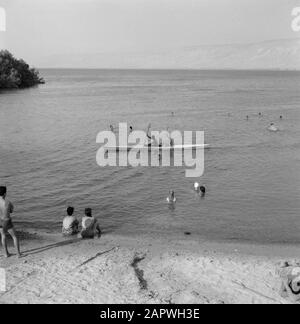 Lake Tiberias an der Flussmünde des Jordan mit Nachstellern am Ufer, Schwimmern und zwei Personen in einem Kanu Datum: 1. Januar 1964 Lage: Israel, Jordanien (Israel River), Lake Tiberias Schlüsselwörter: Kanus, Seen, Ufer, Flüsse, Freizeit, Schwimmen Stockfoto