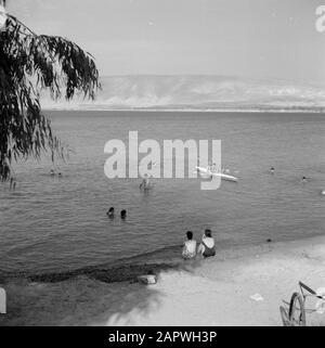 Lake Tiberias an der Flussmünde des Jordan mit Nachstellern am Ufer, Schwimmern und zwei Personen in einem Kanu Datum: 1. Januar 1964 Lage: Israel, Jordanien (Israel River), Lake Tiberias Schlüsselwörter: Hügel, Kanus, Landschaften, Seen, Ufer, Flüsse, Freizeit, Schwimmen Stockfoto