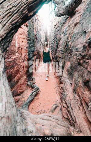 Junge Frau beim Wandern durch den engen Canyon in Utah Stockfoto