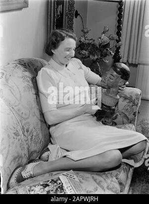 Porträtfotografie Frau D. Smit, posiert auf einer Bank mit einem afrikanischen Holzkopf Datum: 1940 Schlüsselwörter: Skulpturen, Porträts, Posieren, Frauen persönlicher Name: SMIT, D. Stockfoto