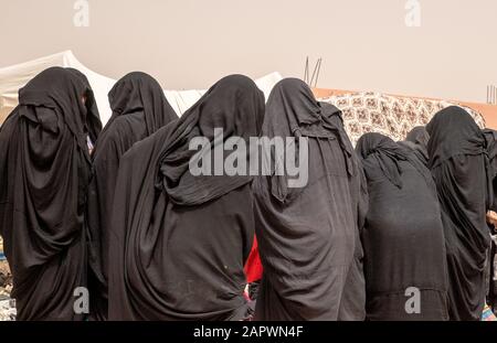 Nahaufnahme mehrerer Frauen, die schwarze Hijabs tragen und als nächstes beten Miteinander verbunden Stockfoto