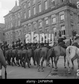 Abdankung der Königin Wilhelmina/Einweihung der Königin Juliana Nach der Tour mit der Goldenen Kutsche durch Amsterdam erschien die königliche Familie wieder auf dem Palastbalkon. Die Zuschauer am De Dam sahen nur das Heck der Ehreneskorte (hier die Detachment Veldartillerie, rechts ein Gelber Reiter), die an der Siegesfahrt durch die Hauptstadt teilnahmen. Datum: 6. September 1948 Ort: Amsterdam, Noord-Holland Schlüsselwörter: Einweihung, Königshaus, Soldaten, Pferde, Paläste, Reiter persönlicher Name: Beatrix, Prinzessin, Bernhard, Fürst, Juliana, Königin Stockfoto