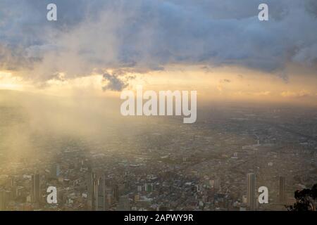 Blick vom Monserrate hinunter mit Blick auf die Stadt Bogota, während die Sonne am Weihnachtstag über die Stadt geht. Stockfoto