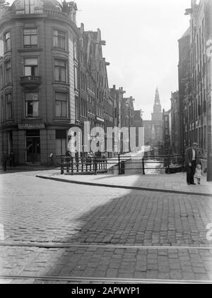 Reportage Amsterdam Oudezijds Kolk von der Prins Hendrikkade in Richtung Oudezijds Voorburgwal mit in der Mitte dem Kolksluis nahe dem Zeedijk. Im Hintergrund der Turm der Oude Kerk Datum: 1933 Ort: Amsterdam, Noord-Holland Schlüsselwörter: Gebäude, Kanäle, Kirchen Stockfoto