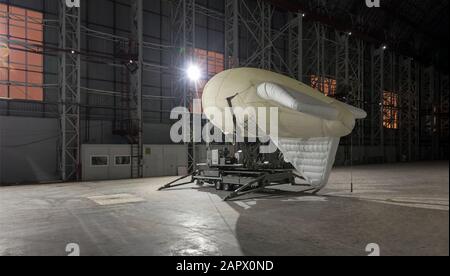 Kleines Luftschiff auf einer Anlegestelle in einem riesigen Flugzeughangar Stockfoto