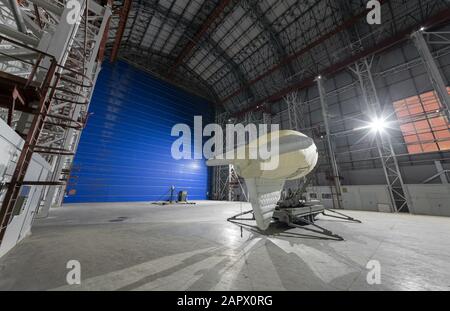 Aerostat auf einer mobilen Anlegestelle in einem riesigen Luftschiffhangar riesige blaue Tore Stockfoto