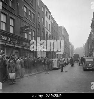 Busker Mad Arthur in Soho, London, Das Publikum steht auf dem Bürgersteig und beobachtet einen Darsteller. Um das Publikum anzulocken, kritisiert er einige Minister Annotation: "Busker" ist das englische Wort für Straßenmusiker, Straßenkünstler Datum: 1947 Ort: England, London Schlagwörter: Publikum, Straßenbilder, Theater Stockfoto