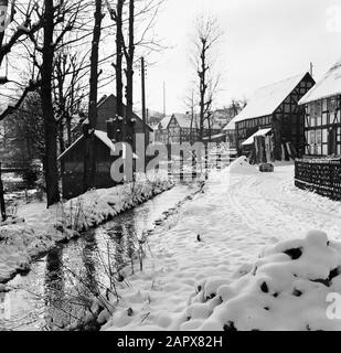 Rothaargebergte der Odeborn mit Fachwerk in Girkhausen im Winter Datum: Undatierter Standort: Deutschland, Girkhausen, Nordrhein-Westfalen, Westdeutschland Schlagwörter: Bäche, Dorfstatuen, Schnee, Winter Stockfoto