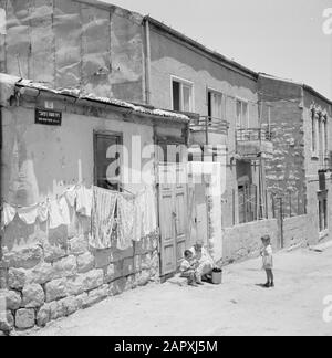 Israel 1964-1965: Jerusalem (Jerusalem), Mea Shearim Street im Distrikt Mea Shearim mit Haushaltsaktivitäten Anmerkung: MEA Shearim, auch Meah Shearim oder hundert Tore genannt, ist einer der ältesten Stadtviertel Jerusalems. Sie wurde ab etwa 1870 von hasidischen Juden erbaut, die bis dahin in der Altstadt lebten. Es war jedoch zu wenig Platz und so kauften sie ein Stück Land nordwestlich der Stadt. Dieses Land, ein Sumpfgebiet, wurde zu Land kultiviert, um ein neues Stadtviertel zu errichten: Meah Shearim. Der Distrikt ist anno 2012 als das extremste orthodoxe jüdische Viertel der Welt bekannt und ist es Stockfoto