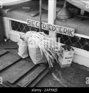 Das Segel-Hausboot Siegfried & Erik am Ufer der seine Taschen mit Lebensmitteln, die vor dem Fabrikschild des Schiffes stehen Datum: 1950 Standort: Frankreich, Paris Schlagwörter: Nachrichten, Gemüse, Schiffe, Hausboote Stockfoto