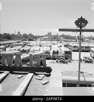 Israel 1964-1965: Tel Aviv, Sabbat Tel Aviv am Sabbat: Busse auf dem Parkplatz des Depots. Im Hintergrund ein Gebäude der Trans World Airlines (TWA). Im Vordergrund große Buchstaben an einer Fassade (Tel Aviv) Datum: 1964 Ort: Israel, Tel Aviv Schlüsselwörter: Busse, Gebäude, Fassadenbuchstaben, jüdische Religion, Parkplätze, Roller, Straßenstatuen, Wracks Stockfoto