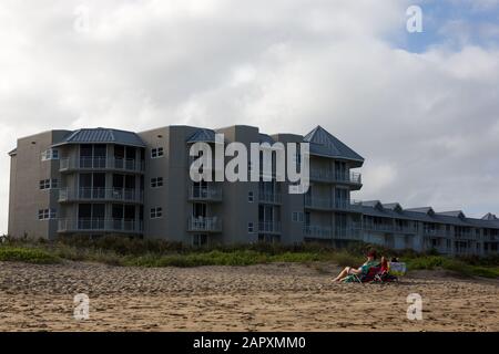 Ein Paar blickt vom Wasser weg, während sie sich am Stuart Beach auf Hutchinson Island, Florida, USA entspannen. Stockfoto