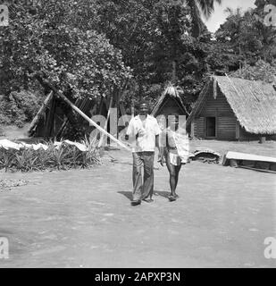 Reise nach Suriname und die niederländischen Antillen Zwei Waldkreolen in einem Dorf, wahrscheinlich Koffiekamp. Verließ den Schulmeister des Dorfes Ganzee Datum: 1947 Ort: Koffiekamp, Suriname Schlüsselwörter: Indigene Bevölkerung, Wohnungen Stockfoto