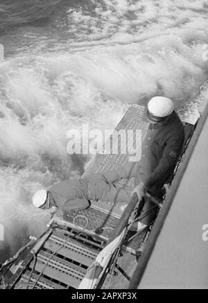 Seereise mit Frau Baloeran Zwei Besatzungsmitglieder überprüfen das Äußere des Schiffes Anmerkung: Dieses Foto ist Teil einer Reihe von Fotos einer Reise mit der MS Baloeran des Rotterdamer Lloyd Datum: 1935 Schlüsselwörter: Schiffe, Seeleute Stockfoto