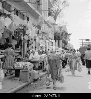 Israel 1964-1965: Tel Aviv, Camel Market Verkäufer von Kleidung und Haushaltsartikeln mit Käufern auf der Straße Datum: 1964 Ort: Israel, Tel Aviv Schlüsselwörter: Haushaltsgegenstände, Kleidung, Straßenbilder, Straßenhändler, Geschäfte Stockfoto