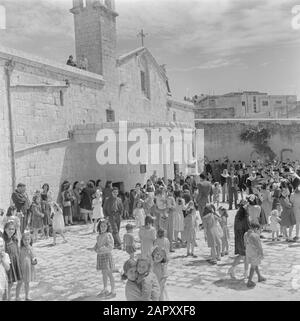 Israel 1948-1949: Galiläa Erwachsene Gläubige und Kinder auf dem Vorplatz der Griechisch-orthodoxen Kirche der Verkündigung in Nazaret in der Nähe des Mariabrons am Ostermorrow Datum: 1948 Ort: Israel, Nazareth Schlüsselwörter: Architektur, Kirchenbauten, Kirchtürme, Kinder, religiöse Feiertage, Wasserquellen Personenname: Maria Stockfoto