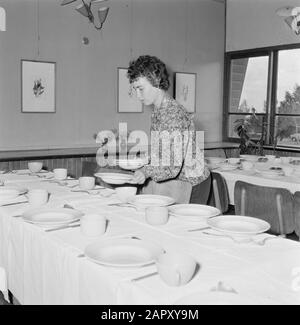 Israel 1964-1965: Gal'ed, seit der Abendfrau damit beschäftigt, die Tische zum Feiern des Saisonabends (Sedermeal) im Gemeinschaftsraum zu verdeckeln Anmerkung: Gal'ed (auch Yitzhak genannt) ist ein Kibbuz im Norden Israels, der sich in der Ebene von Manasse befindet. Im Jahr 2006 hatte sie 405 Einwohner. Seder Evening (auch Seideravond genannt) ist ein Abend zu Beginn des Passahfestes, an dem Juden aus der Haggada lesen (Broschüre über die Geschichte der jüdischen Sklaverei in Ägypten und den Auszug aus Ägypten), 4 Gläser Wein (oder Traubensaft) und ein festliches Sedermahl trinken. Seder bedeutet wörtlich Ordnung oder Ordnung, Stockfoto