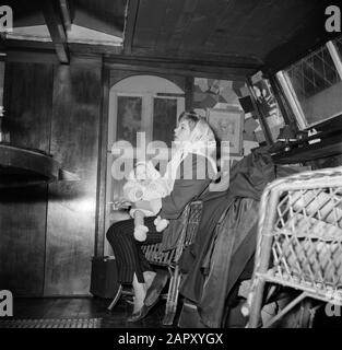 Das Segel-Hausboot Siegfried & Erik am Ufer der seine Frau mit einem Baby auf dem Schoß an Bord des Schiffes Siegfried & Erik in Paris Datum: 1950 Ort: Frankreich, Paris Schlagwörter: Babys, Kerchefs, Innenräume, Frauen Stockfoto