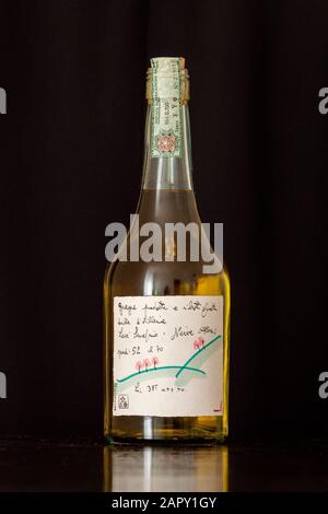 Neive, Alba, Italien - 12. Januar 2020: Original Romano Levi Grappa Flasche mit Zeichnung aus dem Jahr 1995 auf schwarzem Hintergrund. Stockfoto