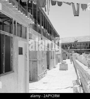 Israel 1964-1965: Jerusalem (Jerusalem), Mea Shearim Blick auf einen Innenhof mit Häusern in einer Galerie und Haushaltstätigkeit Anmerkung: MEA Shearim, auch Meah Shearim oder hundert Tore genannt, ist einer der ältesten Stadtviertel Jerusalems. Sie wurde ab etwa 1870 von hasidischen Juden erbaut, die bis dahin in der Altstadt lebten. Es war jedoch zu wenig Platz und so kauften sie ein Stück Land nordwestlich der Stadt. Dieses Land, ein Sumpfgebiet, wurde zu Land kultiviert, um ein neues Stadtviertel zu errichten: Meah Shearim. Der Distrikt ist anno 2012 als das extremste orthodoxe jüdische Viertel der Welt bekannt Stockfoto