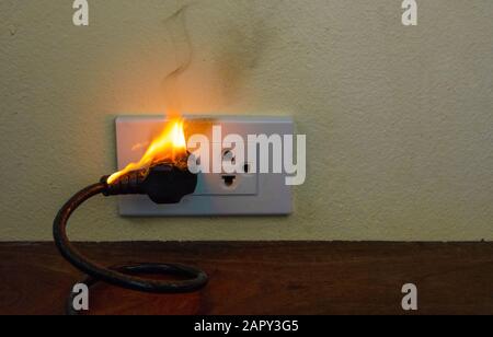 Auf Feuer elektrische Kabel Stecker Buchse wall Partition, Elektrischer Kurzschluss Fehler in Strom Kabel resultierende verbrannt Stockfoto