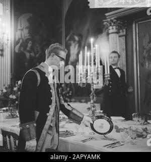 Königin Juliana und Prinz Bernhard geben ein Neujahrsessen im Huis ten Bosch Palast, Den Haag Einer der Lakaien zeigt eines der neuen Zeichen für das Corps [Text gebrochen] Datum: 15. Januar 1964 Ort: Den Haag, Zuid-Holland Schlüsselwörter: Zeichen, Kerzen, Lakaien Stockfoto