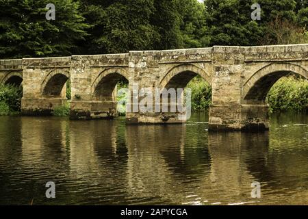 Schöne Aufnahme der alten Essex Bridge mit grünen Bäumen in der Ferne in Shugborough UK. Stockfoto