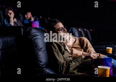 Junge verärgerte Frau, die während des Filmes auf der Schulter ihres Freundes weinte Stockfoto