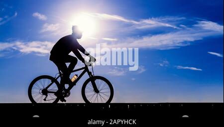 Silhouette des Radfahrers, der mit dem Fahrrad unterwegs ist Stockfoto