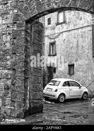 Kleinwagen geparkt vor einem mittelalterlichen Gebäude - Italien Stockfoto